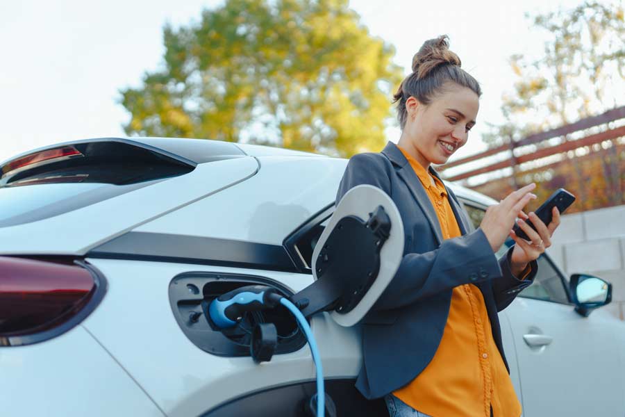 car-charging girl standing next to a car charging