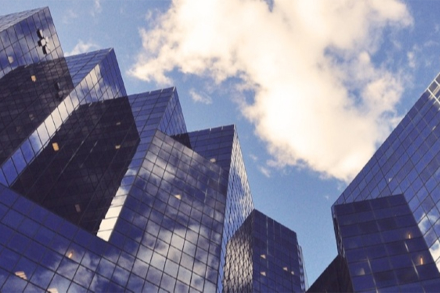 A city skyline against a blue sky with clouds.