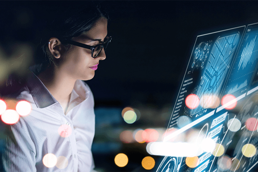 Woman sitting at a computer. Blurred light effects are coming from the screen.