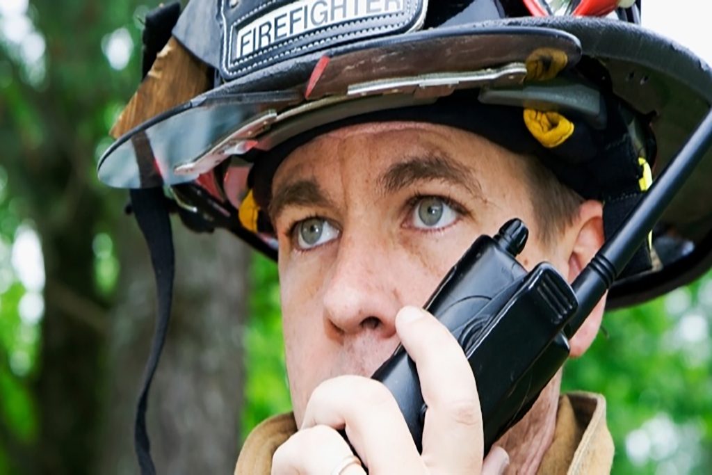 Firefighter speaking on a comms device.