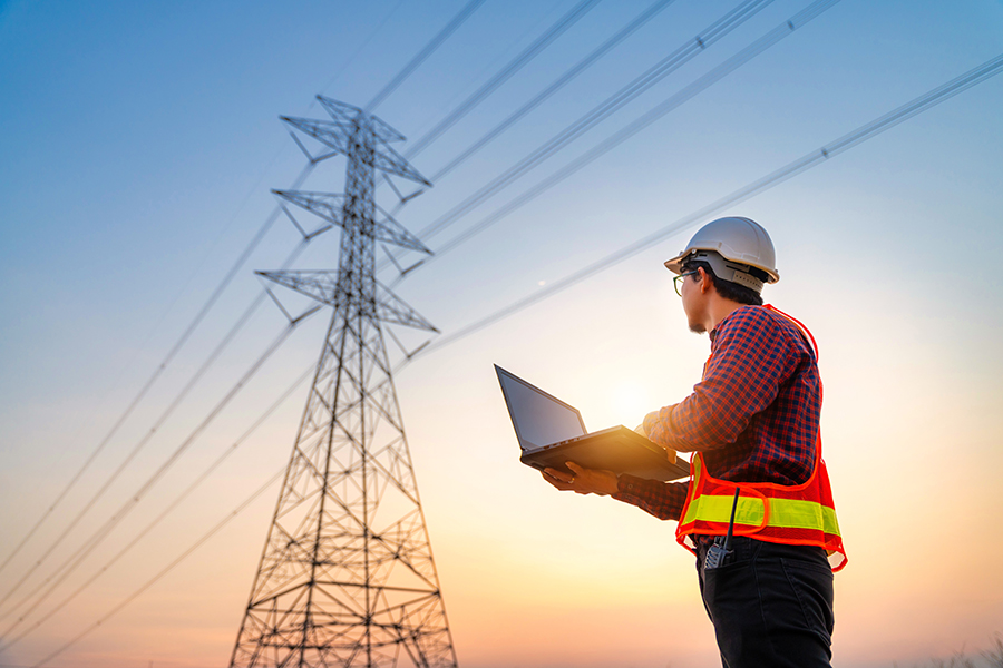 Person looking at a cell tower holding a laptop