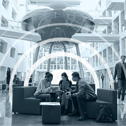 Three people sitting on benches in a lobby